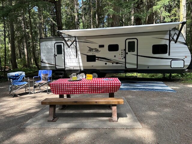 trailer with two chairs a picnic bench and a mat